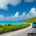 바하마에서 운전할 때 주의할 점 - A scenic Bahamian road winding along turquoise coastal waters under a bright sunny sky, with a moder...